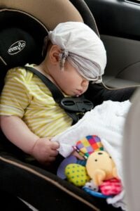 sleeping child on a car seat