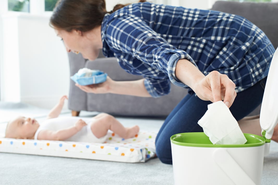 Mother Disposing Of Baby Wipe In Bin